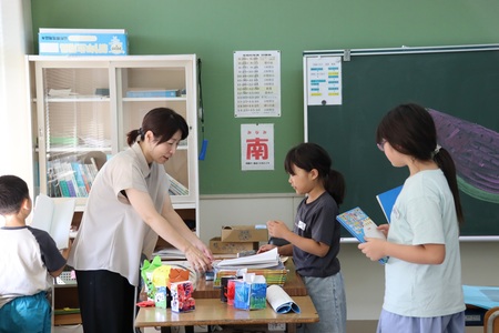 先生に宿題を提出する子どもたち